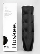 Black coffee cups with Huskee packaging on a white background
