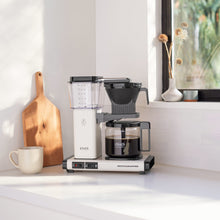 Moccamaster coffee maker on a kitchen counter with a window in the background