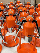 Multiple orange and silver espresso machines arranged in rows.