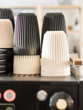 Close-up of Huskee coffee cups on a coffee machine